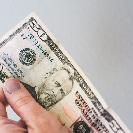 hand holding a fifty dollar bill