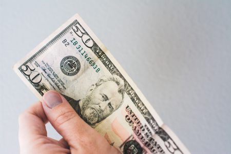 hand holding a fifty dollar bill