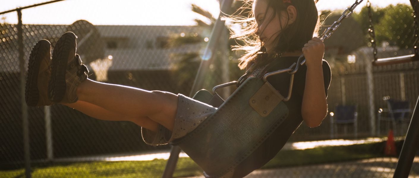 backlit girl on swing
