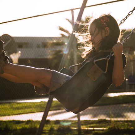 backlit girl on swing
