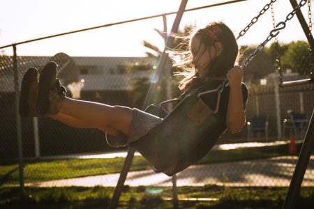 backlit girl on swing