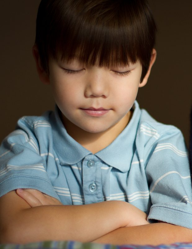child folding arms in prayer